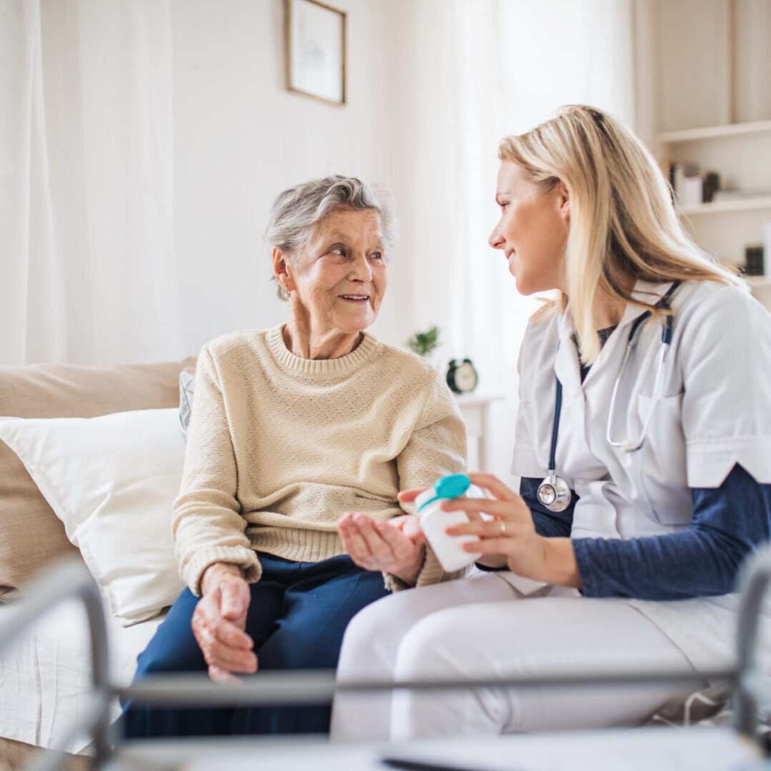 A health visitor explaining a senior woman how to take pills. A health visitor explaining a senior woman how to take pills
