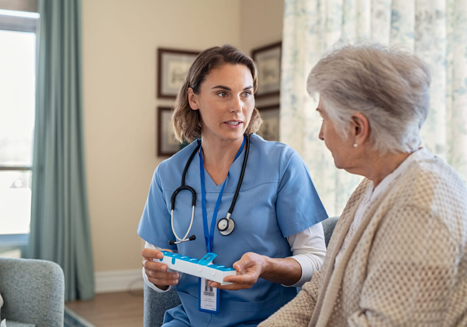 Nurse explaining medicine dosage to senior woman at nursing home