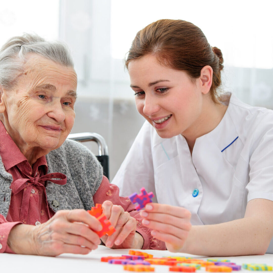 Senior woman suffering from dementia with her elder care nurse